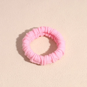 Dettaglio dell'elastico per capelli rosa chiaro spesso con morbida trama a coste