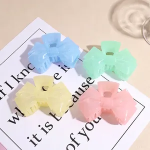 Set of four pastel acrylic bow hair claws in macaron colors on a minimalist background