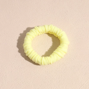 Vista macro dettagliata di un elastico per capelli giallo chiaro spesso con trama a coste
