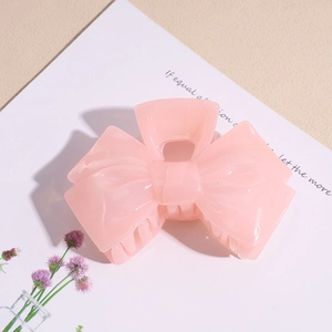 Close-up of pink jelly acrylic bow hair claw clip with semi-transparent resin texture