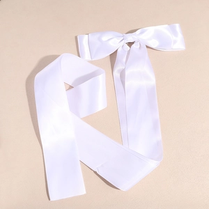 Detailed view of elegant white satin bow hairclip with long flowing silk ribbons