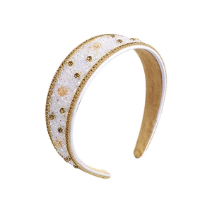 Sparkling wide headband with crystal rhinestones and gold braided edge trim on white base