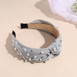 Detail of light blue denim headband featuring pearl accents and sparkling rhinestones
