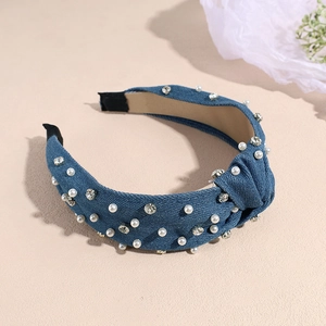 Detail of blue denim headband featuring decorative pearls, rhinestones and knotted center design