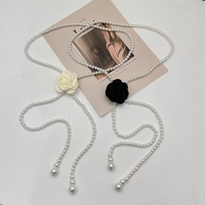 Detail of camellia flower pearl chains in black and white fabric with large drop pendants
