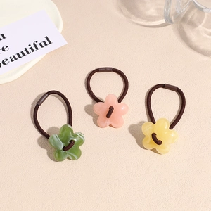 Lot de 3 chouchous fleurs en acrylique rose jaune et vert sur fond de sable fin