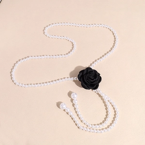 Detail view of pearl body chain featuring a 3D black fabric camellia flower ornament