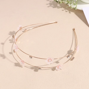 Detail of double-layer golden headband with pink cherry blossoms and small rhinestones