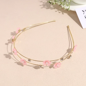 Close-up of golden double-layer headband with pink cherry flowers and pearls