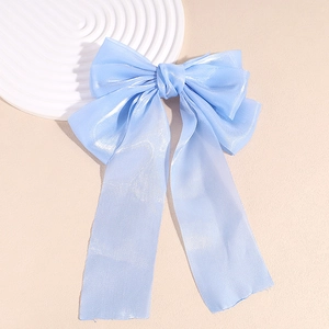 Détail de la pince à cheveux nœud bleu clair montrant la texture d'organza et le ruban élégant