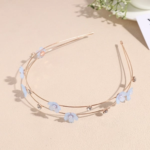 Detail of double-layer gold headband with blue fabric flowers and faux pearls