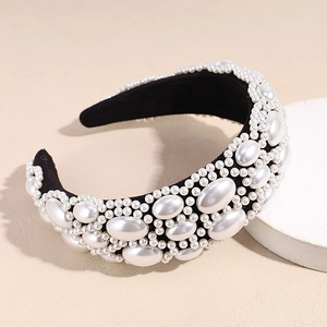 Macro detail of Baroque style wide headband with white faux pearls on black fabric