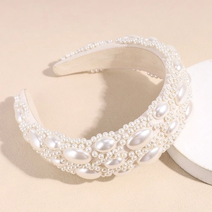 Close-up of padded cream headband featuring large baroque pearls and intricate beadwork