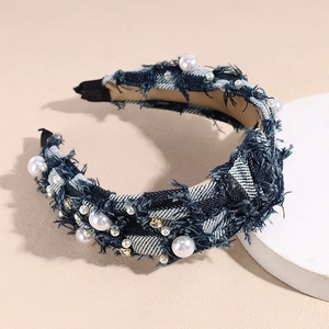 Detailed view of denim texture headband with pearls and rhinestones on a display stand