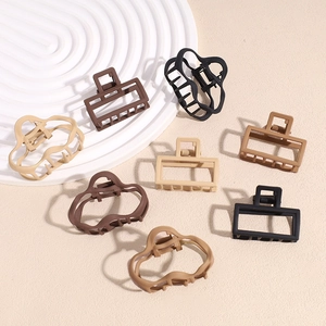 Matte finish irregular metal hair claws in earth tones shown on aesthetic display stand