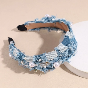 Detailed texture of denim headband featuring distressed edges with white pearls and rhinestones