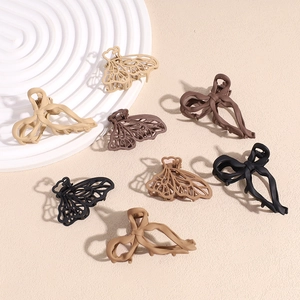 Matte finish small hair claws in earthy tones arranged on a white rippled tray