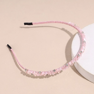 Detailed close-up of pink headband featuring crushed crystals and small white rhinestones