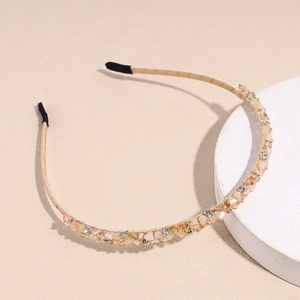 Detail of gold headband featuring champagne beads and sparkling crystals on stone stand