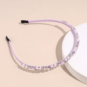 Close-up of thin purple headband with lavender crystals and sparkling rhinestones