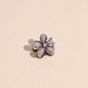 Detailaufnahme einer Mini-Haarklammer mit lila Glitzerblüten und Strassstein-Mitte