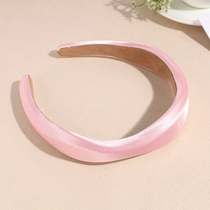 Vue détaillée d'un serre-tête rembourré en satin rose pâle avec un fini soyeux élégant