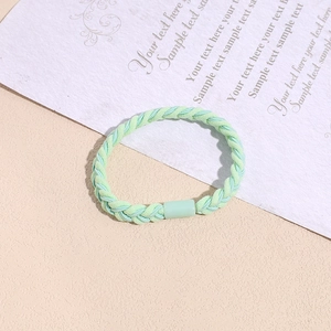 Detail of woven mint green hair tie with braided texture and cylindrical clasp
