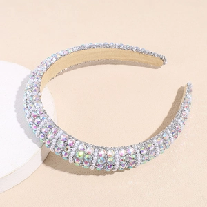Detailed macro view of sparkling rhinestones and white pearls on thick sponge headband