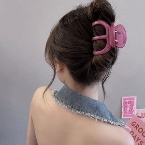 Pince à cheveux rose pour cheveux épais, portée par un modèle pour un style élégant