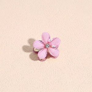 Detailansicht der rosa Blumen-Haarklammer mit glitzerndem Harz und zentralem Kristall