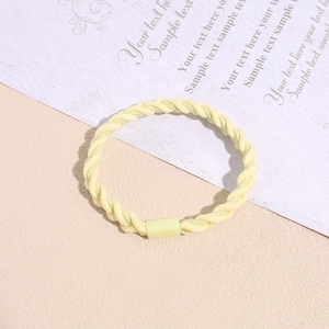 Detail of yellow braided elastic hair tie with reinforced buckle and texture