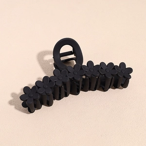 Close-up of a 13cm matte black shark hair claw clip with a six-flower pattern design