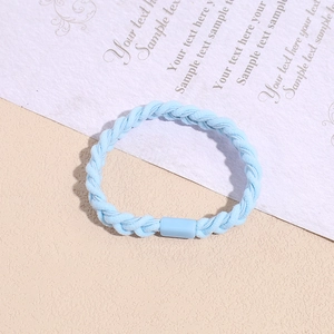 Close-up of light blue braided hair tie with smooth plastic buckle on textured surface