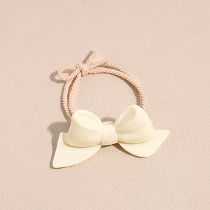 Minimalist cream resin bow hair tie with high elastic spiral woven rope on beige background