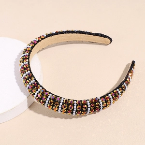 Detailed shot of padded headband with colorful rhinestones and white pearls on black fabric