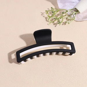 Pince à cheveux rectangulaire noir et blanc mat pour femme sur fond beige
