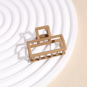 Detail of matte rectangle hair claw clip on white grooved display tray
