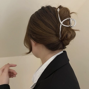 Pince à cheveux serpent en métal argenté portée par un mannequin de style moderne