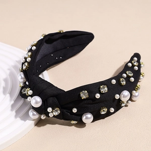 Detail view of black knotted headband featuring elegant white pearls and crystals