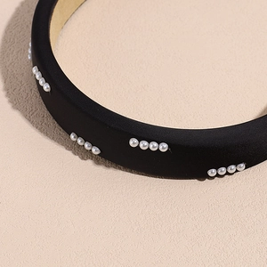 Cerchietto largo in spugna nera con file di perle bianche per uno stile elegante e chic