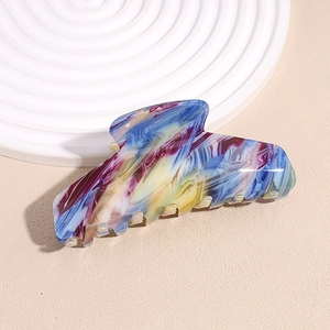 Dettaglio di un fermaglio per capelli con trama a marmo blu e viola con finitura lucida