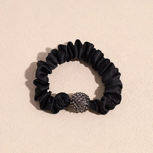 Close-up of black satin scrunchie with sparkling rhinestone sphere ornament detail