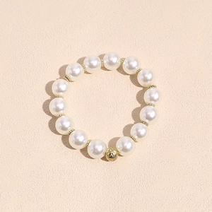 Detalle de coletero de perlas elegante con cuenta dorada texturizada y perlas lisas