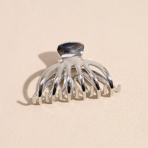 Vue détaillée de la pince à cheveux métallique argentée en forme de serpent brillant
