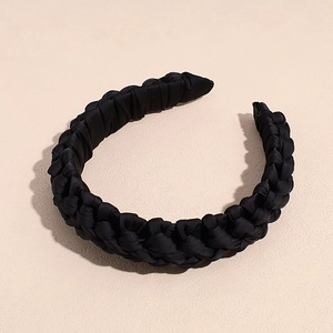 Gros plan sur un serre-tête tressé noir avec éclat satiné et texture plissée chic