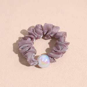 Detail showing lavender organza hair scrunchie texture with iridescent pearl ornament