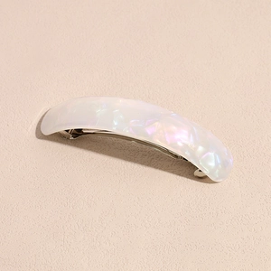 Detail of elegant acetate hair clip with iridescent pearl finish and silver spring clip