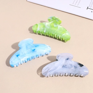 Three acrylic starry hair claws in green blue and white with marble texture