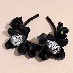 Detail of Halloween headband with black fabric roses and mesh-covered white skulls