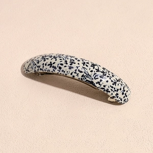 Detail of elegant acetate hair clip with leopard floral pattern on silver metal spring